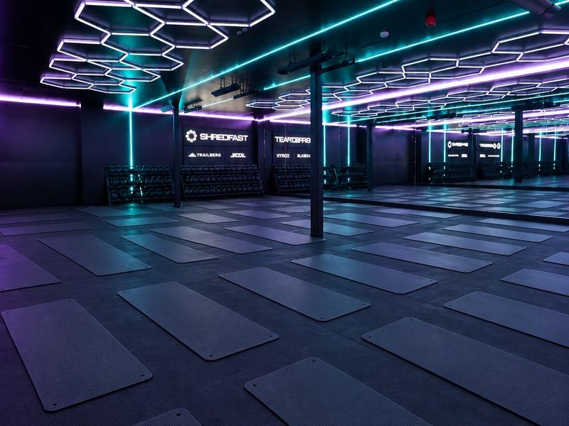 The ShredFast Trafford training floor with hexagonal ceiling lights and rows of mats